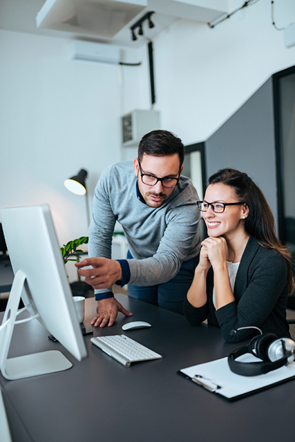 two,confident,young,business,people,looking,at,computer,monitor.,he